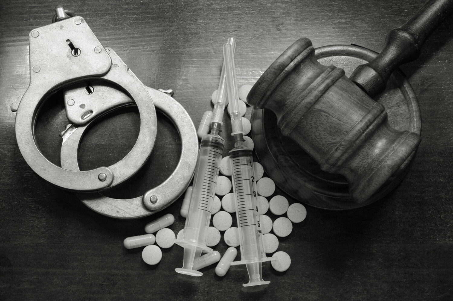 stock-photo-judge-s-gavel-with-handcuffs-drugs-and-syringes-on-wooden-table-drugs-concept-302620112